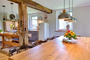 a kitchen and dining room with a large wooden table at Landhäuschen Anderswo in Bocholt