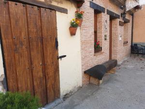 a large wooden door with a bench next to a building at casaruraltiarosa in Quintanilla del Agua