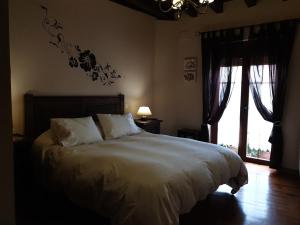 a bedroom with a large bed and a window at casaruraltiarosa in Quintanilla del Agua