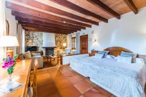 Agroturismo Ses Illes في كوستيتيكس: غرفة نوم مع سرير وغرفة معيشة