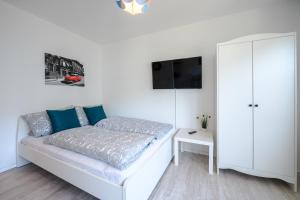 - une chambre blanche avec un lit et une armoire blanche dans l'établissement Helles Apartment in TOP-Lage mit Parkplatz, à Magdebourg