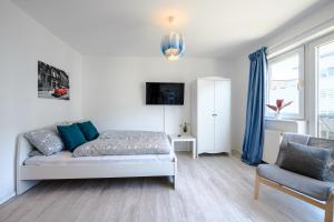 - un salon avec un lit et une chaise dans l'établissement Helles Apartment in TOP-Lage mit Parkplatz, à Magdebourg