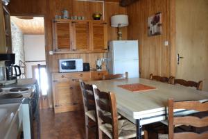 een keuken met een tafel met stoelen en een koelkast bij Le Pont de l' Alp in Le Monêtier-les-Bains +10 foto's