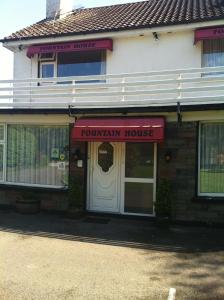 a front entrance to a townlin house with a red awning at Fountain House B&B in Macroom