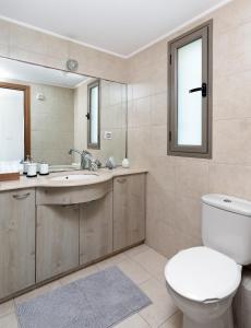 een badkamer met een toilet, een wastafel en een spiegel bij Water Front Blue Lguna Garden Apartment 2bd in Herzliyya B