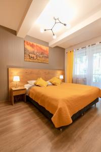 a bedroom with a large orange bed with yellow pillows at Kurort Kozubnik - Apartamenty Daglezja w cichej okolicy nad strumykiem- Dream Apart in Porąbka