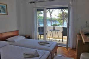 a hotel room with two beds and a balcony at Covahouse in Jelsa