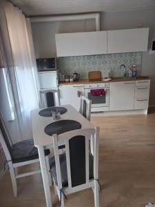 - une cuisine avec une table et des chaises blanches dans la chambre dans l'établissement Tamula apartament, à Võru