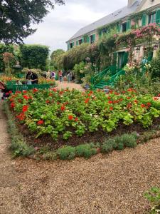 a garden with red flowers in a yard at Le Clos de l'Eglise - Inès in Giverny +8 photos