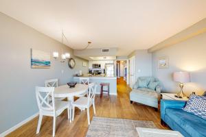een woonkamer met een blauwe bank en een tafel bij Seacrest #202 in Gulf Shores