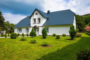 ein weißes Haus mit einem blauen Dach in der Unterkunft ENKLAWA NAD KWISĄ [APARTAMENT 1] in Świeradów-Zdrój