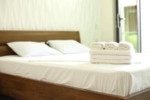 una pila de toallas sentadas encima de una cama en Magnetiti Hotel, en Ureki