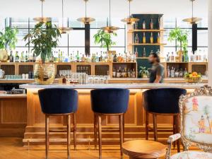 a bar with blue chairs and a man in the background at ARRIVE Memphis in Memphis