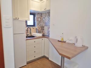 a kitchen with white cabinets and a wooden counter top at Holiday home in Starigrad-Paklenica 40978 in Starigrad-Paklenica