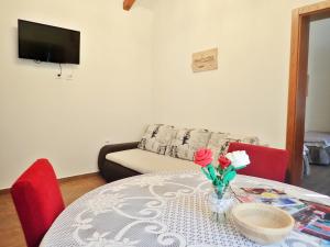 a living room with a table with flowers on it at Holiday home in Starigrad-Paklenica 40978 in Starigrad-Paklenica