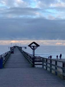 un molo in legno con persone che camminano sulla spiaggia di Apartment in Pruchten 41178 a Pruchten