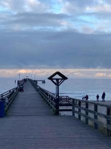 un muelle de madera con gente caminando por la playa en Apartment in Pruchten 41178, en Pruchten