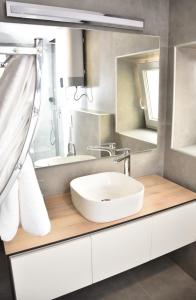 un bagno con un lavandino bianco e uno specchio di Apartments Hidden paradise Rovinj a Rovigno (Rovinj) Altre 44 foto