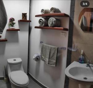 a bathroom with a toilet and a sink at Hospedaje Wiruyana in Cotacachi