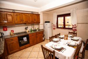 eine Küche mit einem Tisch und Stühlen sowie einem Kühlschrank in der Unterkunft Charming Family Large Apartment in Bragança
