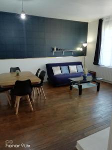 - un salon avec un canapé bleu et une table dans l'établissement Confort et Élégance dans le Bouchon de Champagne, à Troyes