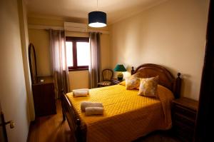 sypialnia z żółtym łóżkiem i 2 ręcznikami w obiekcie Charming Family Large Apartment w mieście Bragança