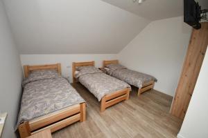 a room with two beds in a room at Dom w głębi lasu in Suwałki