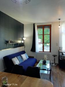 un salon avec un canapé bleu et une table en verre dans l'établissement Confort et Élégance dans le Bouchon de Champagne, à Troyes