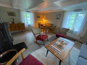 a living room with a table and chairs at Storhella - Feriehus med fantastisk beliggenhet in Sennesvik