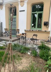 einen Garten mit einem Tisch und Stühlen vor einem Gebäude in der Unterkunft Студія з внутрішнім півповерхом. in Mykolajiw