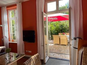 eine offene Tür zu einer Terrasse mit einem Sonnenschirm in der Unterkunft Villa Sonntag in Plau am See