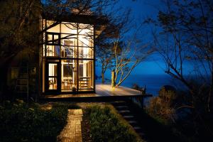 una casa con vistas al océano por la noche en Izu Cliff House - Vacation STAY 29217v, en Ihama