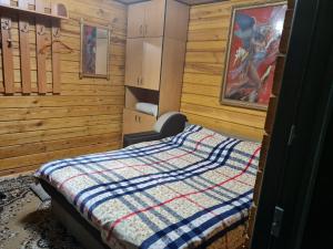 a bedroom with a bed with a quilt on it at Деревянный 2-х комнатный домик in Kyiv