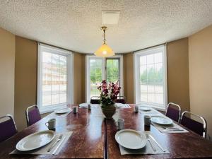 une salle à manger dotée d'une table avec des assiettes et des fleurs dans l'établissement Travelodge by Wyndham Niagara Falls Lundys Lane, à Niagara Falls