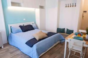 - une chambre avec un lit bleu et une table dans l'établissement Studio in Porto Santa Margherita 40284, à Porto Santa Margherita
