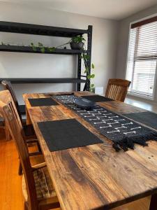 a dining room table with chairs and a wooden table at Central Executive Spa Apartment in Ballarat
