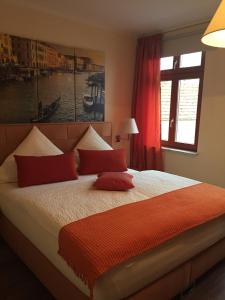 a bedroom with a large bed with red pillows at Venedig und Amsterdam in Plau am See