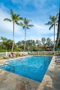 a swimming pool with palm trees in the background at Sandpiper 120B in Princeville