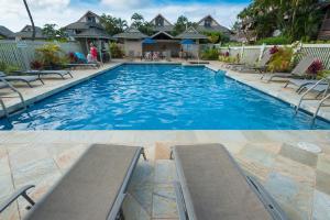 a large swimming pool with benches in a house at Sandpiper 120B in Princeville
