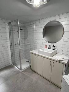 a bathroom with a shower and a sink and a mirror at Central Executive Spa Apartment in Ballarat