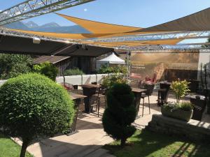 a patio with tables and chairs under a canopy at Chez Stéphane et Maria in Chamoson