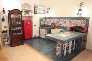 eine Küche mit einer Theke und einem roten Kühlschrank in der Unterkunft La Siciliana-di fronte la Cattedrale in Palermo