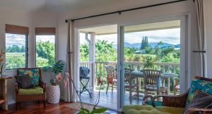 uma sala de estar com uma porta de vidro deslizante que leva a uma varanda em Hanalei Bay Villa 26 em Princeville