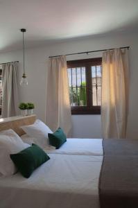 a bedroom with two beds and a window at Apartamentos Tres Llaves Palacio de Vela de los Cobos in Úbeda