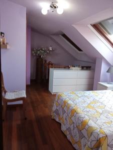 a bedroom with a bed and a dresser at Apartamento Duplex Vigo in Vigo