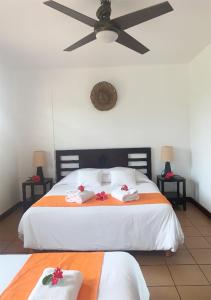 a bedroom with a bed and a night stand at Hotel Oasis de Kiamu in Lifou