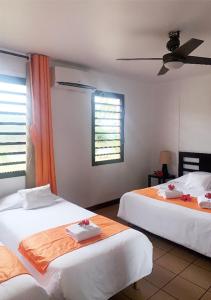 a hotel room with two beds and a television at Hotel Oasis de Kiamu in Lifou