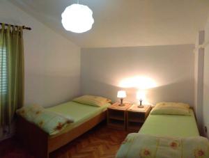 twee bedden in een kleine kamer met twee lampen bij Apartment in Zadar/Zadar Riviera 8183 in Smirić