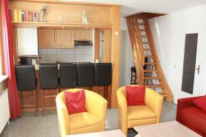 a living room with two chairs and a kitchen at Apartments in Westerland/Sylt 38535 in Westerland