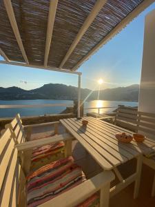 a picnic table on a deck with a view of the water at Astra Serifos in Livadion